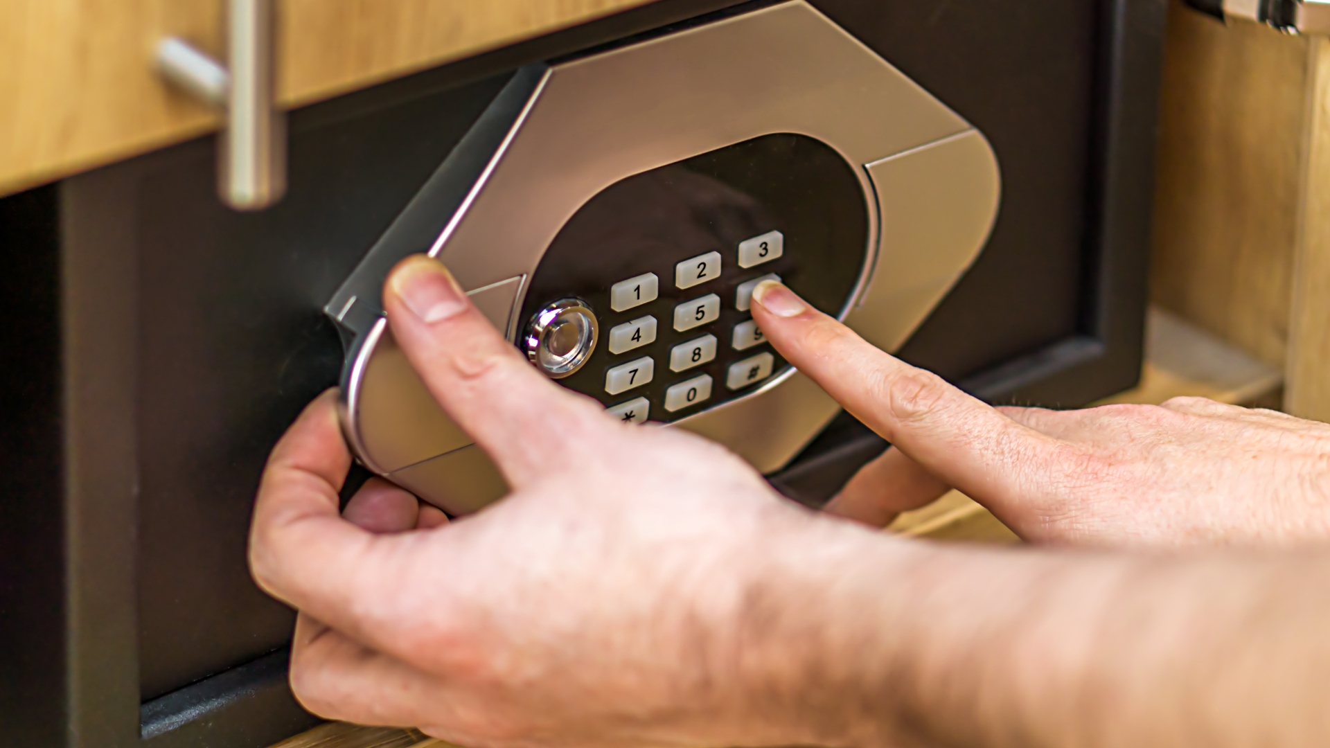 A man accessing an electronic safe in a cabinet