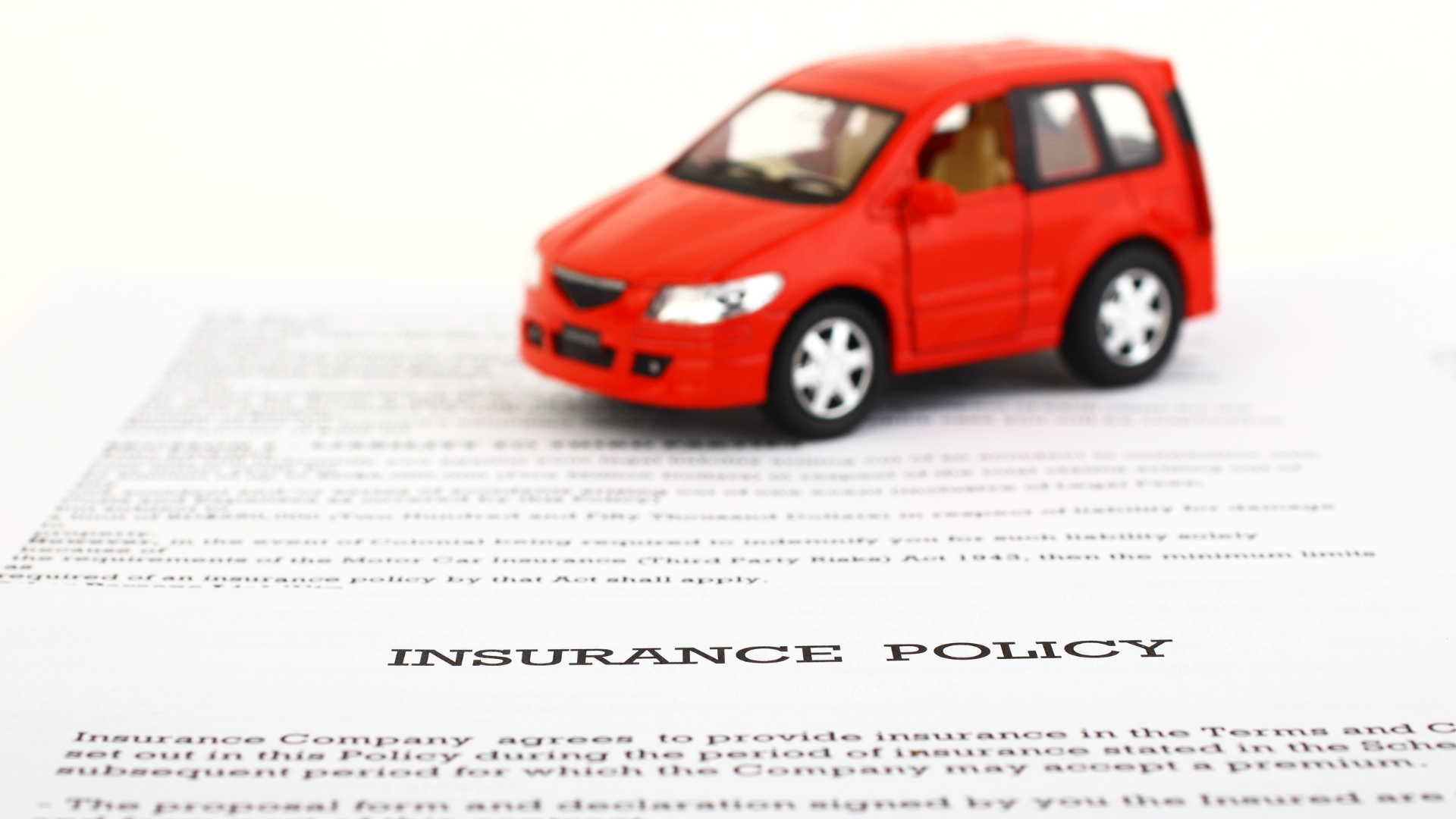 A toy car on top of an insurance policy