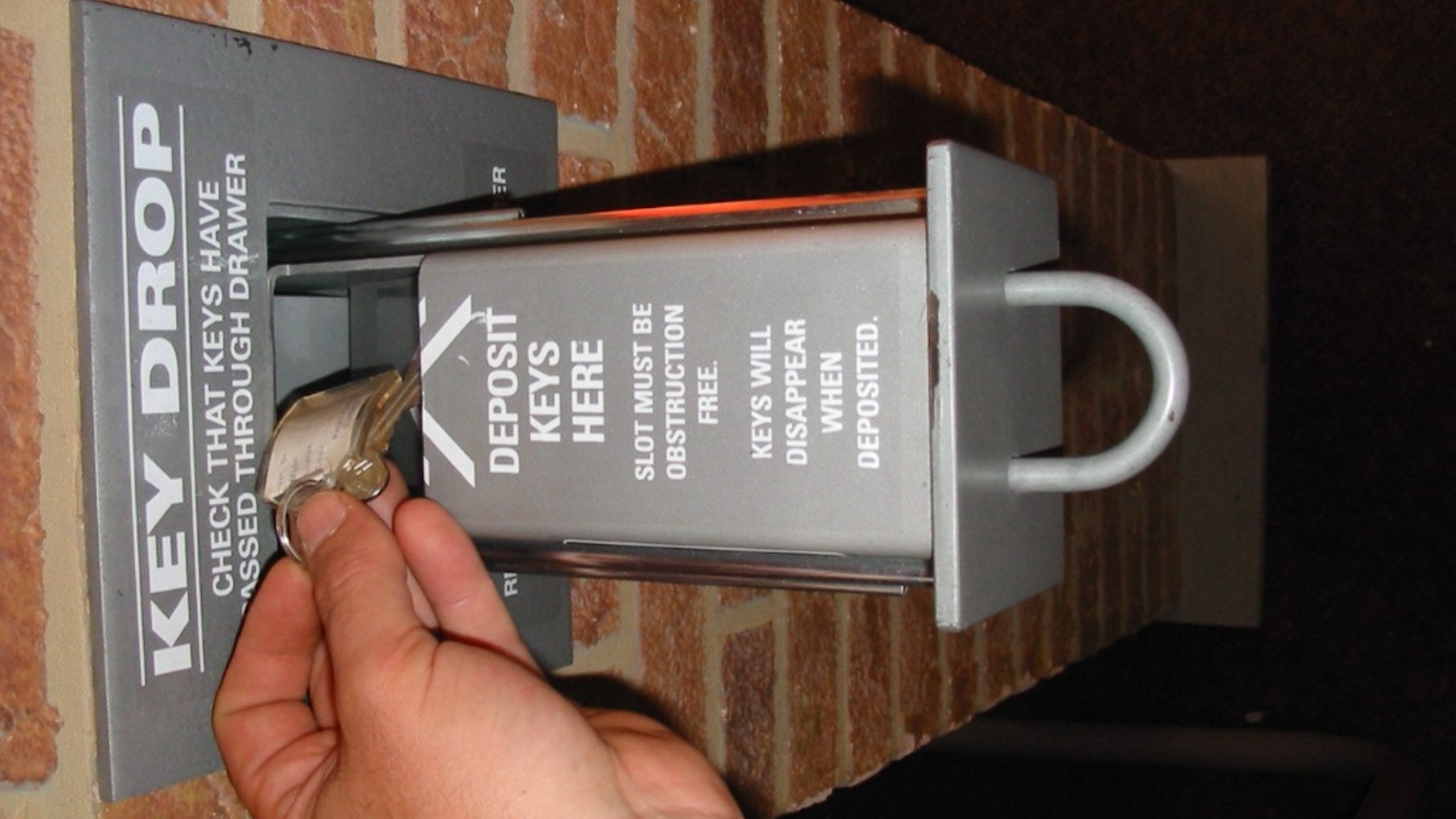 A user retrieving a key from a key drop box