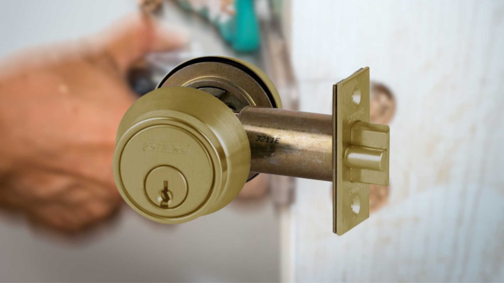 The locksmith performs deadlatch installation and assembles the parts on a wooden door.