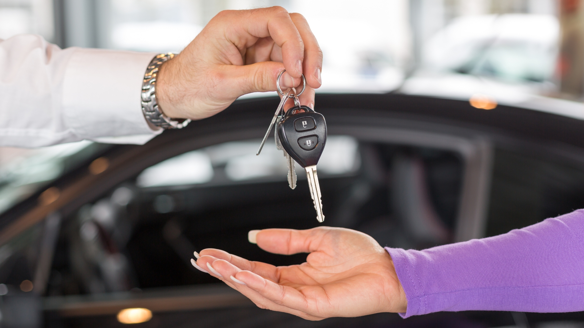 A duplicate car key is being handed over.