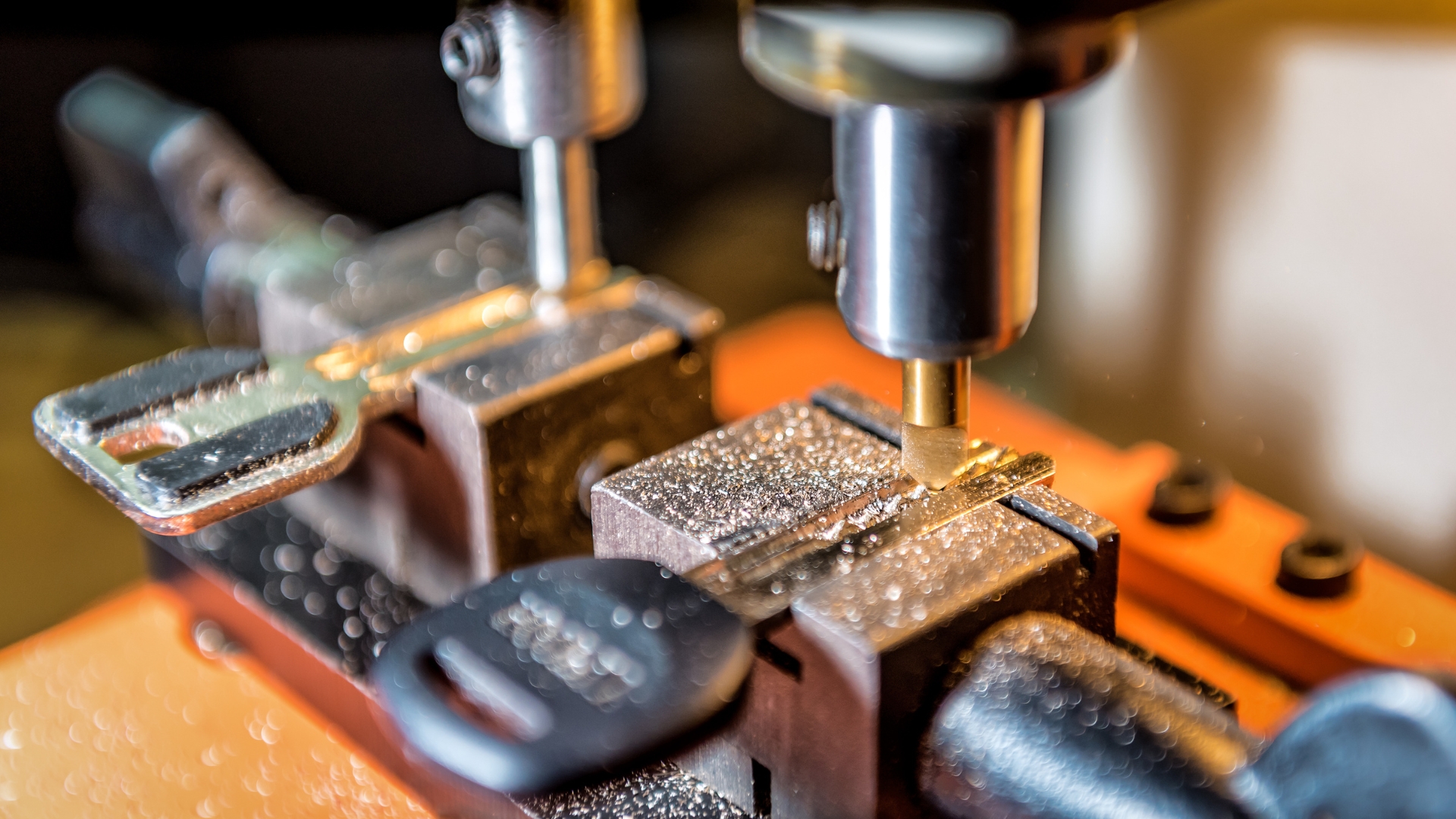 A duplicate car key is being crafted on a machine.