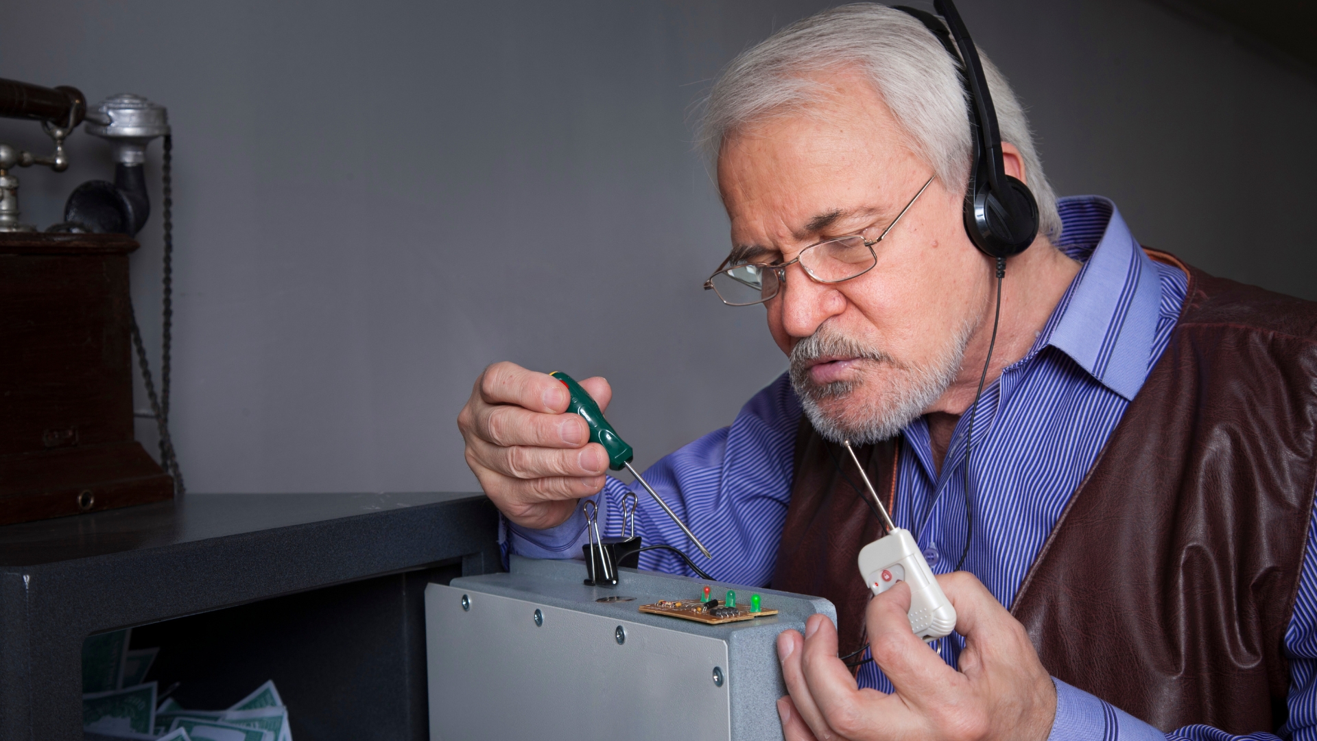 A safe locksmith working on a safe's circuit board