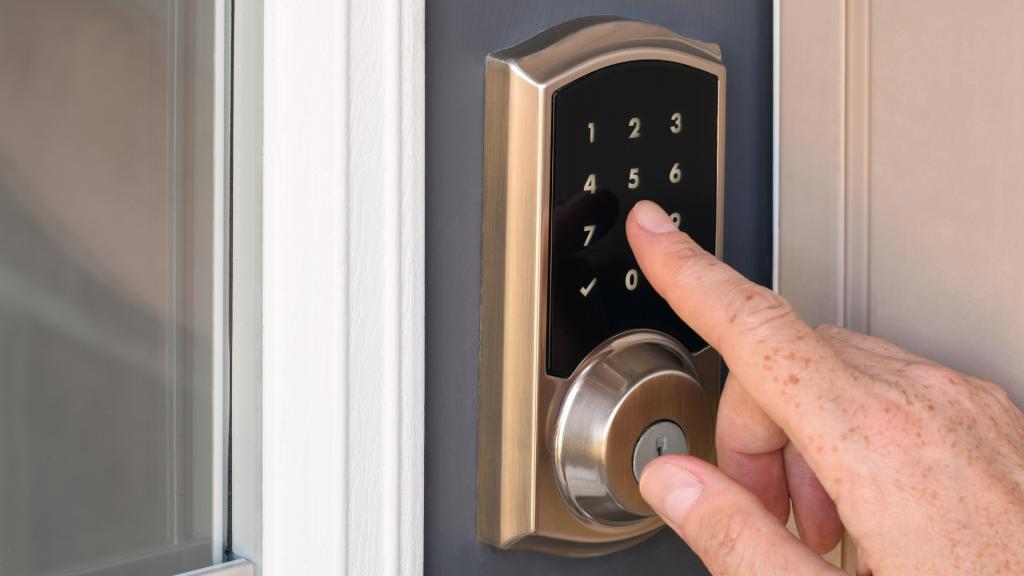 Digital lock installation on a residential front door with a homeowner entering a code on the keypad for keyless access.