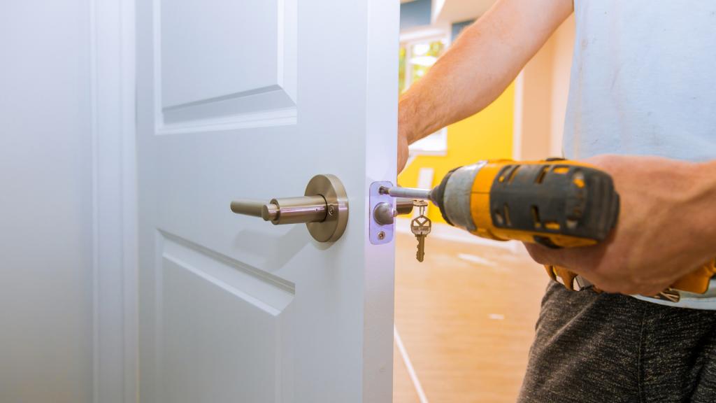 Locksmith replacing a residential door lock as part of a guide on whether to rekey or replace locks
