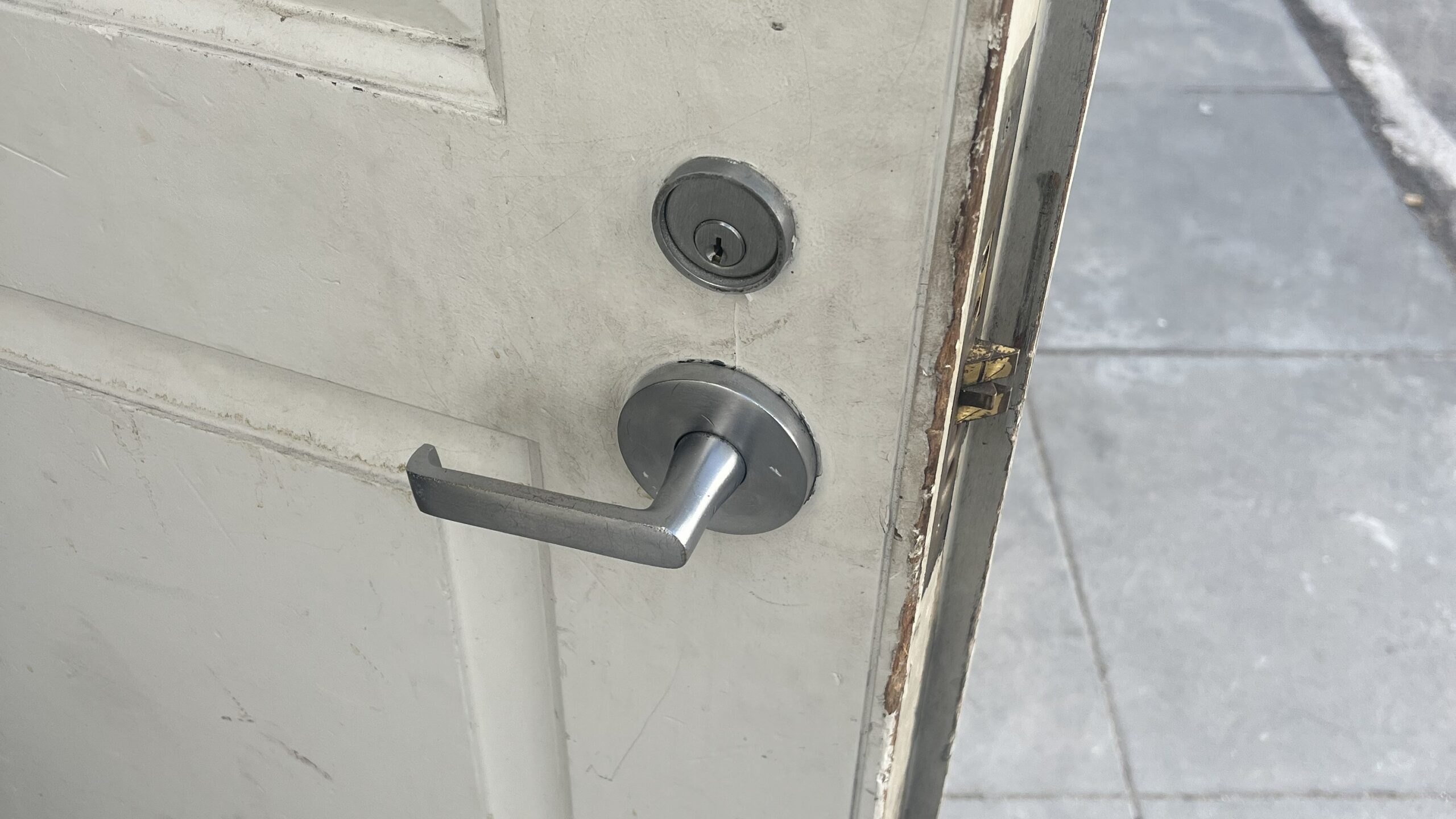 Close-up view of a metal lever handle and deadbolt lock on an open white door, highlighting a completed residential lockout service.
