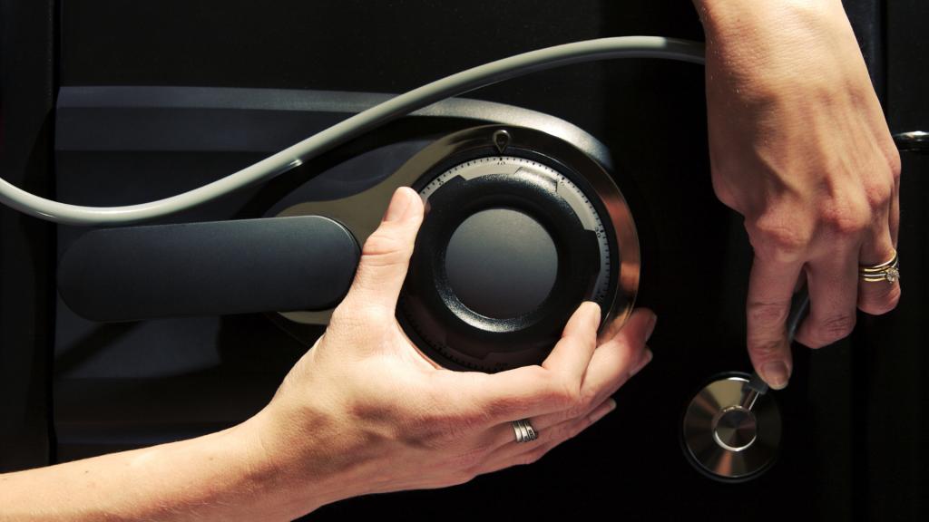 Person adjusting the combination dial and handle on a safe that won’t unlock